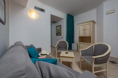 a living room with a gray couch and chairs at Helios Hotel in San Vito lo Capo