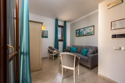 a living room with a couch and two chairs at Helios Hotel in San Vito lo Capo