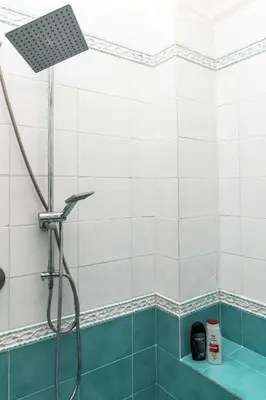 a shower in a bathroom with blue and white tiles at Ai quattro canti di città, appartamento in centro in Palermo