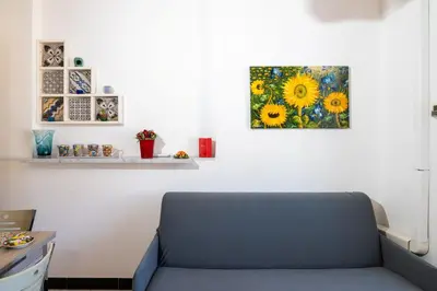 a couch in a room with a painting on the wall at Ai quattro canti di città, appartamento in centro in Palermo