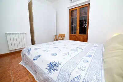 a bedroom with a bed with a blue and white blanket at Villa Linda, Exceptional Sea-view in Terrasini