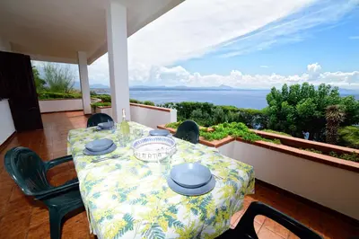 a table and chairs on a balcony with a view of the ocean at Villa Linda, Exceptional Sea-view in Terrasini