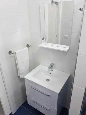 a white bathroom with a sink and a mirror at Villetta Azzurra in Alcamo Marina