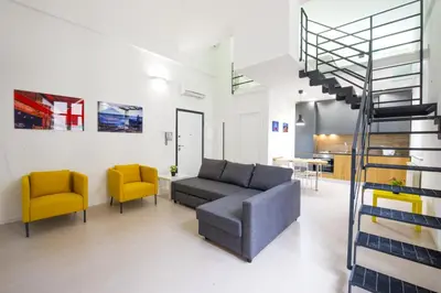 a living room with a gray couch and two yellow chairs at Loft 18 by Wonderful Italy in Palermo