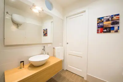 a bathroom with a white bowl sink on a wooden counter at Loft 18 by Wonderful Italy in Palermo