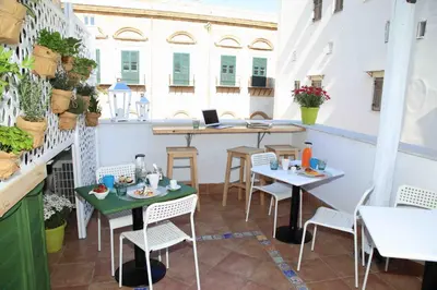 a group of people sitting at tables in a restaurant at Jardin De France in Palermo