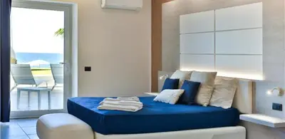 a bedroom with a blue bed and a balcony at Hotel Sporting Club in Altavilla Milicia