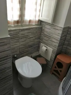 a small bathroom with a white toilet and a window at Room holiday 