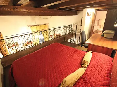 a bedroom with a red bed and a balcony at Orologio del Massimo in Palermo