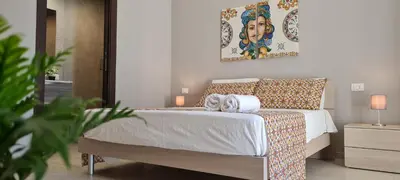 a bedroom with a bed and a painting on the wall at House Orlando in Sferracavallo