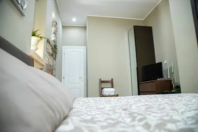 a bedroom with a white bed and a television at House Orlando in Sferracavallo