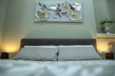 a bedroom with a bed with flowers on the wall at House Orlando in Sferracavallo