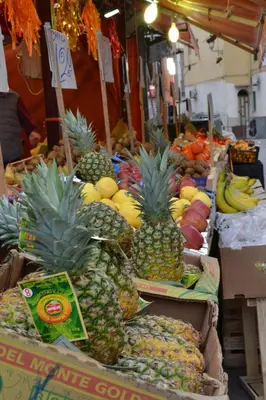 a display of pineapples and other fruits in a market at Mediterraneo in Palermo
