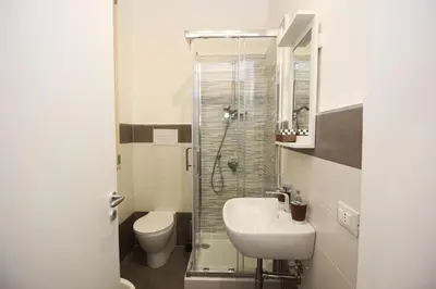 a bathroom with a toilet and a sink and a shower at Oasi del Turista in Palermo