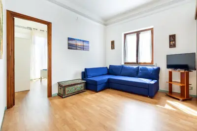 a living room with a blue couch and a television at Porta Carini Residence in Palermo