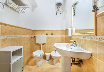 a bathroom with a white sink and a toilet at Porta Carini Residence in Palermo