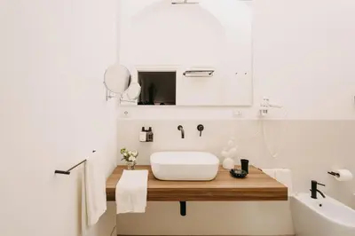 a white bathroom with a sink and a tub at Palazzo Natoli Boutique Hotel in Palermo
