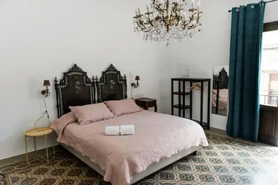 a bedroom with a large bed with a chandelier at B&B Malvasia in Palermo