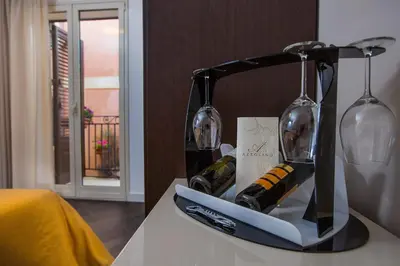 a container of wine bottles and glasses on a table at Palazzo Ducale Suites in Monreale