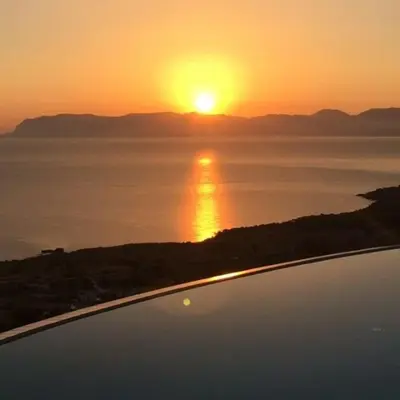 a sunset over a body of water with the sun setting at Hotel Antica Cascina Del Golfo in Scopello