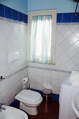 a bathroom with a toilet and a sink and a window at Villa Aga in Campofelice di Roccella