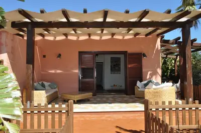 a patio with a wooden pergola and a house at Villa Le Meraviglie in San Vito lo Capo