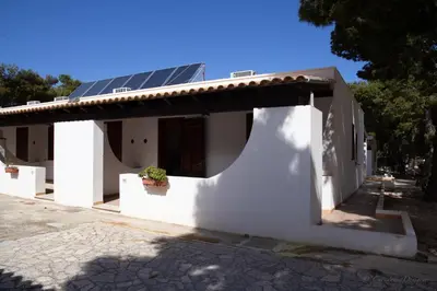 a white house with a solar panel on the roof at Camping Village La Pineta in San Vito lo Capo