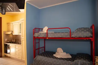 two bunk beds in a room with a kitchen at Camping Village La Pineta in San Vito lo Capo