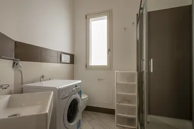 a bathroom with a washing machine and a sink at Borgo Aranci - Villetta a schiera Lavanda - A8 in Castellammare del Golfo
