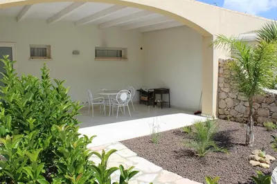 a patio with a table and chairs in a building at Borgo Aranci - Villetta Peonia B3 - Castellammare del Golfo in Castellammare del Golfo