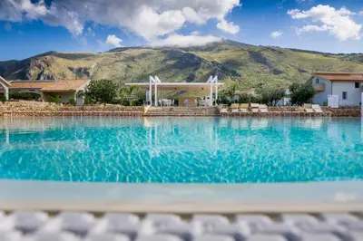 a swimming pool with a mountain in the background at Borgo Aranci - Villetta Peonia B3 - Castellammare del Golfo in Castellammare del Golfo