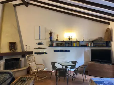a living room with a table and chairs and a tv at Villa Mariza in Scopello