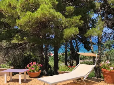 a white chair and a table and some plants at Villa Mariza in Scopello