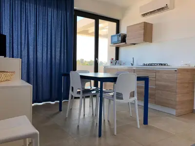 a kitchen with a table and chairs in a room at Villa Vo' Scurá in Alcamo Marina