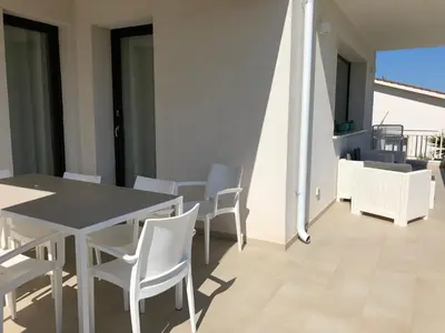 a dining room with a table and chairs on a balcony at Villa Vo' Scurá in Alcamo Marina