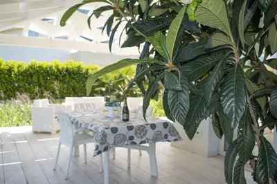 a table and chairs and a plant on a patio at Borgo Aranci - Villa Tulipano in Castellammare del Golfo