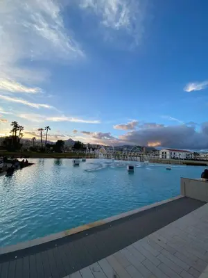 a large swimming pool with a sunset in the background at SUITE 188 - Welcome in Palermo