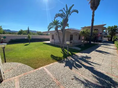 a house with palm trees and a yard at Villa Paloma in Castellammare del Golfo