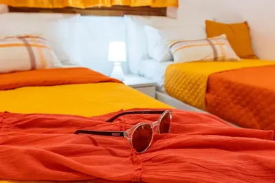 a pair of glasses sitting on top of two beds at Il Faro Casa Vacanze Design Privacy Comfort e Posto Auto in San Vito lo Capo