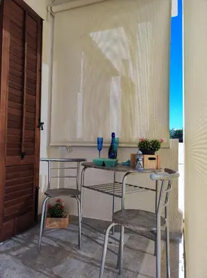 a table and chairs in a room with a window at Il Faro Casa Vacanze Design Privacy Comfort e Posto Auto in San Vito lo Capo