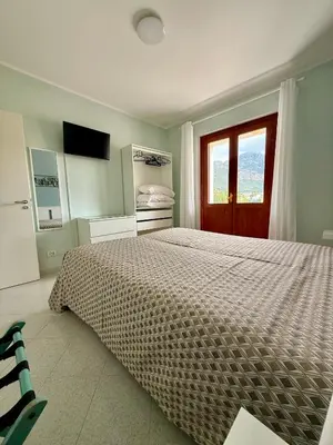 a bedroom with a large bed and a window at Yucca Apartment in San Vito lo Capo
