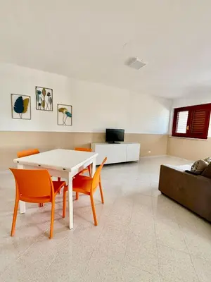 a living room with a white table and chairs at Yucca Apartment in San Vito lo Capo