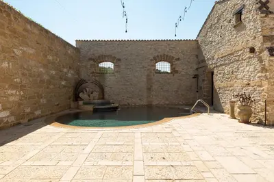 a courtyard with a swimming pool in a building at Tenute Baglio Passofondo in Alcamo