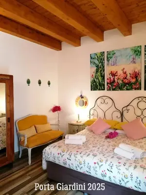 a bedroom with a bed and a chair at Casa Busari in Palermo