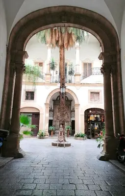 an entrance to a building with a statue in the middle at Casa Busari in Palermo