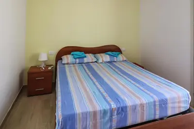 a bedroom with a bed with a striped comforter and a night stand at CASA 