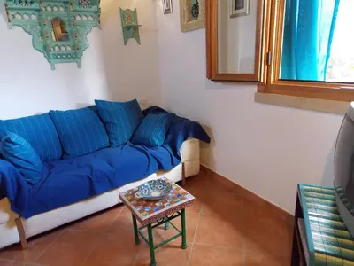 a blue couch in a living room with a table at Villa vista MARE a MÀKARI in San Vito lo Capo
