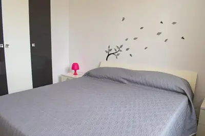 a bedroom with a bed and a pink lamp on a table at Borgo Aranci - Villetta a Schiera A1 in Castellammare del Golfo
