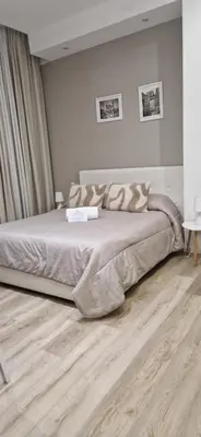 a bedroom with a large bed and a wooden floor at Due Passi Suite in Palermo