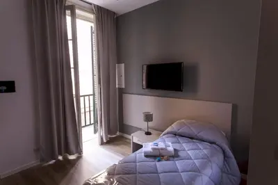 a bedroom with a bed and a television on the wall at Due Passi Suite in Palermo